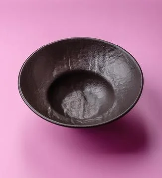An empty round ceramic plate on a pink background as a kitchen utensil. An .. Stock Photos