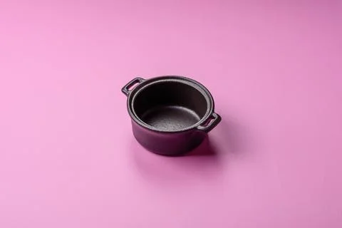 An empty round ceramic plate on a pink background as a kitchen utensil. An .. Stock Photos