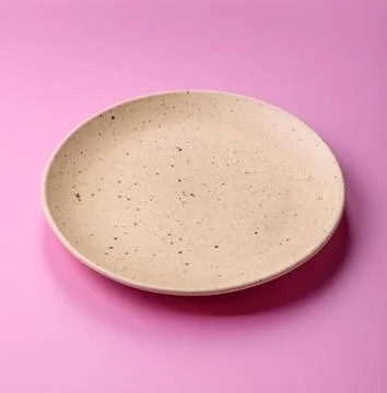 An empty round ceramic plate on a pink background as a kitchen utensil. An .. Stock Photos