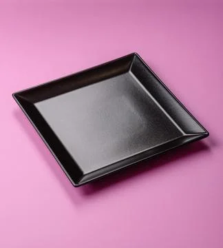 An empty round ceramic plate on a pink background as a kitchen utensil. An .. Stock Photos