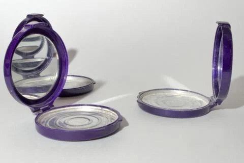Empty round foundation powder case with mirror, that reflect each other Stock Photos