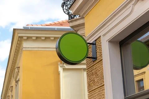 Empty round hanging sign mounted on a building exterior, perfect for cafe b.. 写真素材
