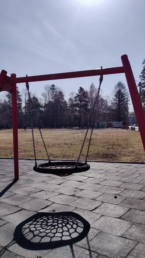 Empty round nest swing swaying gently in sunny playground. Stock Footage 328968309