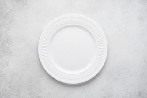Empty round plate on light gray concrete background. Stock Photos