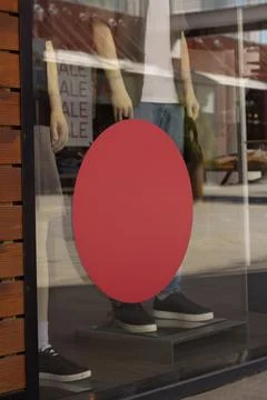 Empty round red sticker on glass window of clothing store Stock Photos