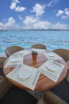 Empty round table made of wood in a restaurant with a sea view Stock Photos