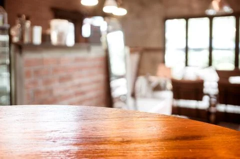 Empty round table top at coffee shop blurred background with bokeh light,Te.. Stock Photos