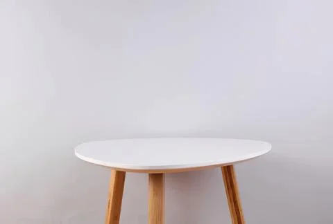 Empty round white table with wooden legs in a minimal room Stock Photos