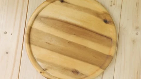 Empty round wooden cutting board turning Stock Footage 336037810
