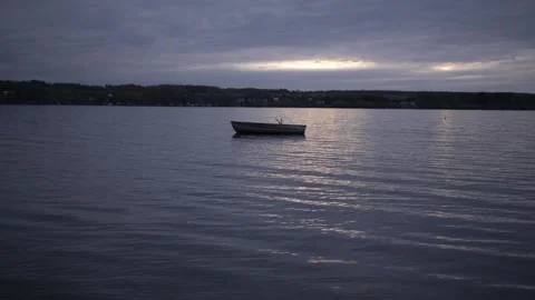 Empty Row Boat Floating on Lake at Dusk Stock Footage 236417881