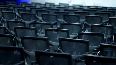 Empty rows of modern black mesh conference chairs fill a large auditorium Stock Footage 325668834