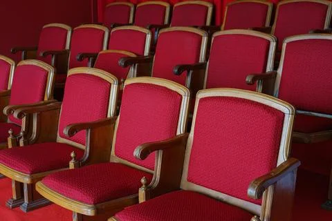 Empty rows of retro red theater or cinema seats with red upholstery Stock Photos