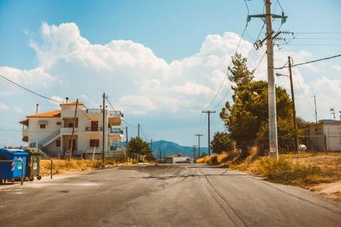 Empty rural road going through prairie under cloudy sky in Greece, Corinth. V Stock Photos