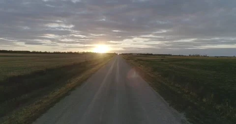 Empty rural road in the middle of fields at sunset Stock-Footage 146858572