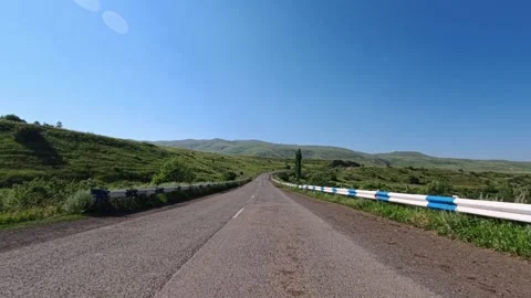 Empty rural road stretches into distance under bright sunny sky Stock Footage 340077337