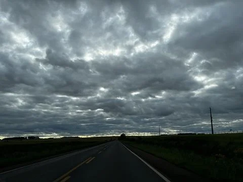 Empty rural road under dramatic dark cloudy sky in Cruz Alta, Rio Grande do.. Stock Photos