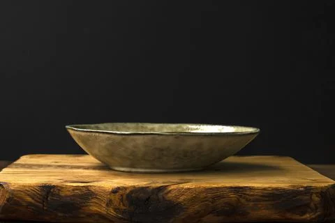 Empty rustic style plate on a toasty oak cutting board on a black background. Foto stock