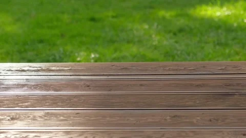 Empty rustic table top with blurred green grass landscape background. Abstract Stock Footage 320807691
