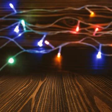 Empty rustic wooden table with colorful, blurry Christmas fairy lights on a.. Stock Photos
