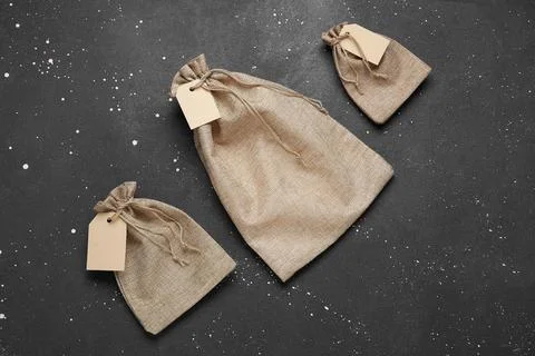Empty sacks with tags on grunge black background Stock Photos