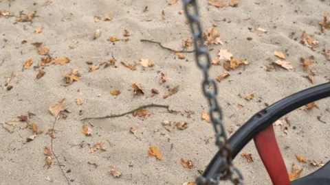 An empty, sad, children's swing moving in the autumn of the year. Video stock 106532738