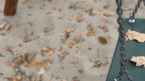 An empty, sad, children's swing moving in the autumn of the year. Stock Footage 106537367