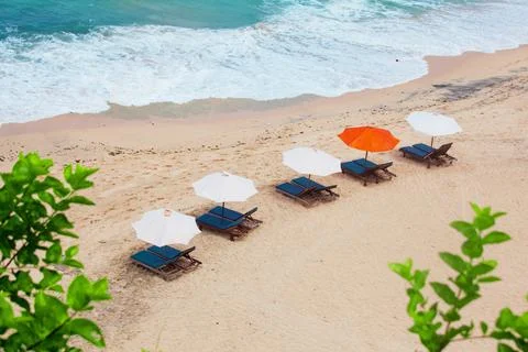 Empty sand beach background with bright tent, recliners and surf waves, view Stock-Fotos
