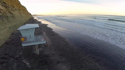 Empty sand coastline with ocean waves breaking and lifeguard tower station. Stock Footage 126799845