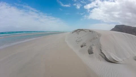 Empty sandy beach and dunes beside turquoise sea Photos