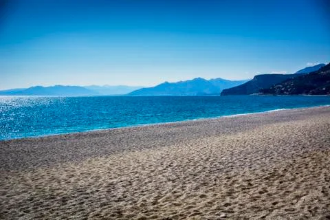 Empty sandy beach during a clear day Stock Photos