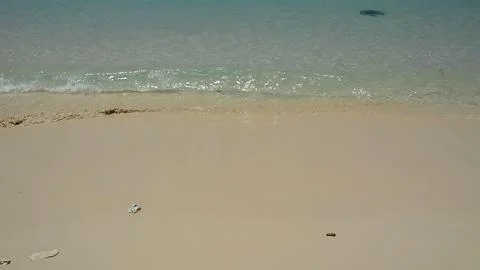 Empty sandy beach with gentle waves and clear water Stock Photos