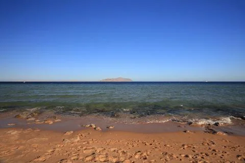 Empty sandy beach with Red Sea water and Tiran Island Egypt Sharm El Sheikh 库存照片