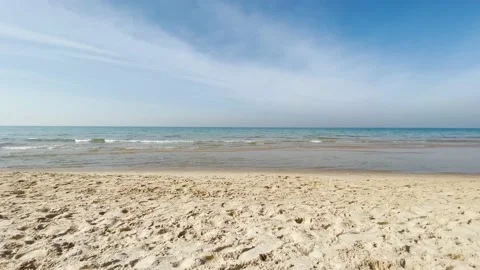 Empty sandy beach on a sunny day, calm sea without waves, the camera flies o Stock-Footage 146522191