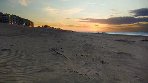 Empty Sandy Beach at Sunset Along a Coastal Town Seafront With Dunes and Ev.. Foto stock