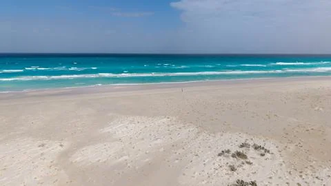 Empty sandy beach with turquoise ocean and clear blue sky Stock Photos