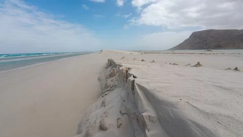 Empty sandy beach with turquoise sea and distant hill Photos