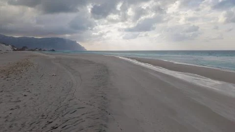 Empty sandy beach under dramatic cloudy sky Stock Photos