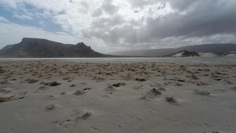 Empty Sandy Beach Under Dramatic Clouds Stockfoto's