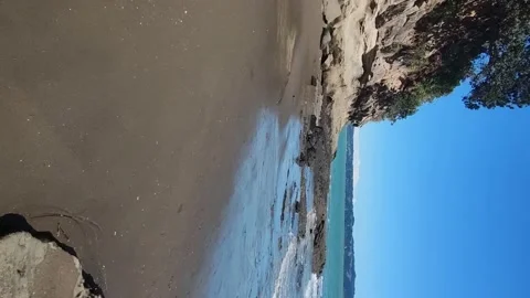 Empty sandy beach view with rocks and water, seashore, tourist destination Stock Footage 167945878