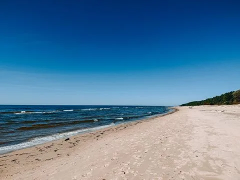 Empty Sandy Beach with Waves and Clear Blue Sky Horizon Stock-Fotos