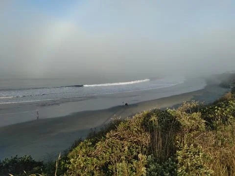 Empty sandy beach with waves rolling onto the shore Stock Photos
