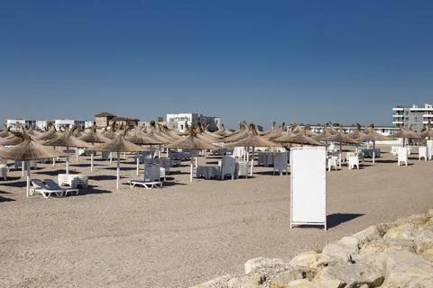 Empty Sandy Resort Beach with Reed Umbrellas and Blank Billboard Copy Space Stock Photos