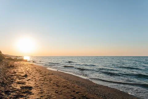 Empty sandy sea beach at sunset. Evening sea landscape. Stock Photos