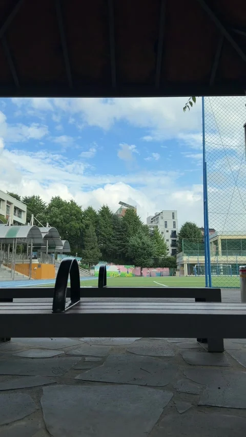 Empty School Athletic Field Viewed Through a Shaded Pavilion Bench Stock Footage 340020584
