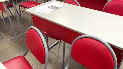 Empty school class with red chairs with papers on desks. video 库存影片 166582957