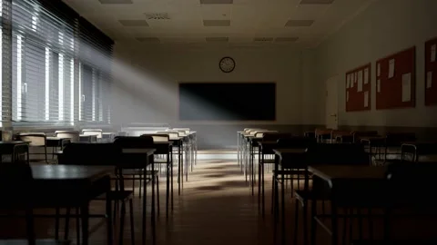 Empty school classroom with sunlight beams through window blinds 库存影片 145767899