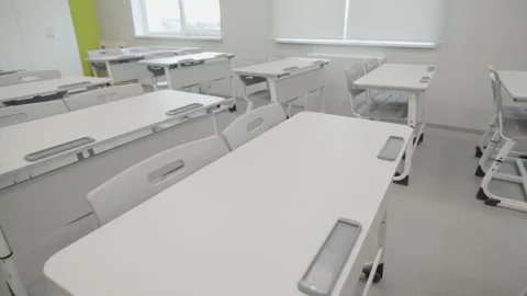 Empty school desks stand in modern light classroom Stock Footage 335644408