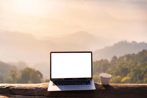 Empty screen laptop with cup of coffee and camera with mountain view Fotos Stock