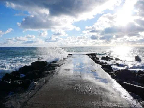 Empty sea shore with a pier on a spring sunny day Stock Photos