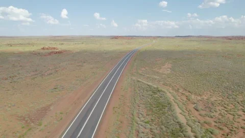 Empty Sealed Highway Stretching Through Remote Australian Outback Under Blue Sky Stock Footage 345279696
